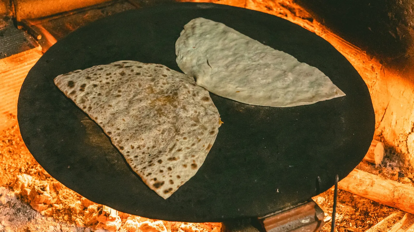 Galettes de manioc fines en cuisson sur une plaque chaude, recette de la cassave antillaise